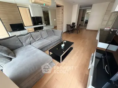 Spacious modern living room with stylish gray sofa and sleek wooden flooring