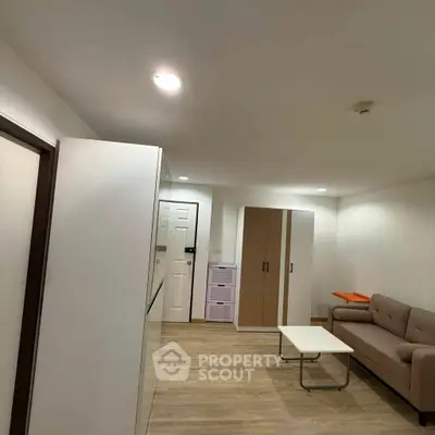 Modern living room with sleek furniture and wooden flooring in a cozy apartment.