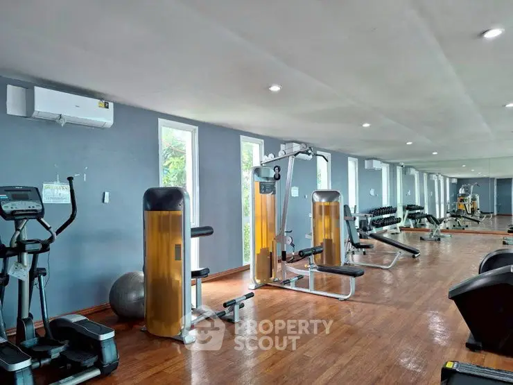 Spacious modern gym with state-of-the-art fitness equipment and mirrored walls.