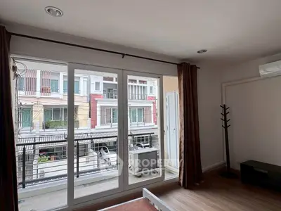 Spacious living room with large windows and balcony view in modern apartment.