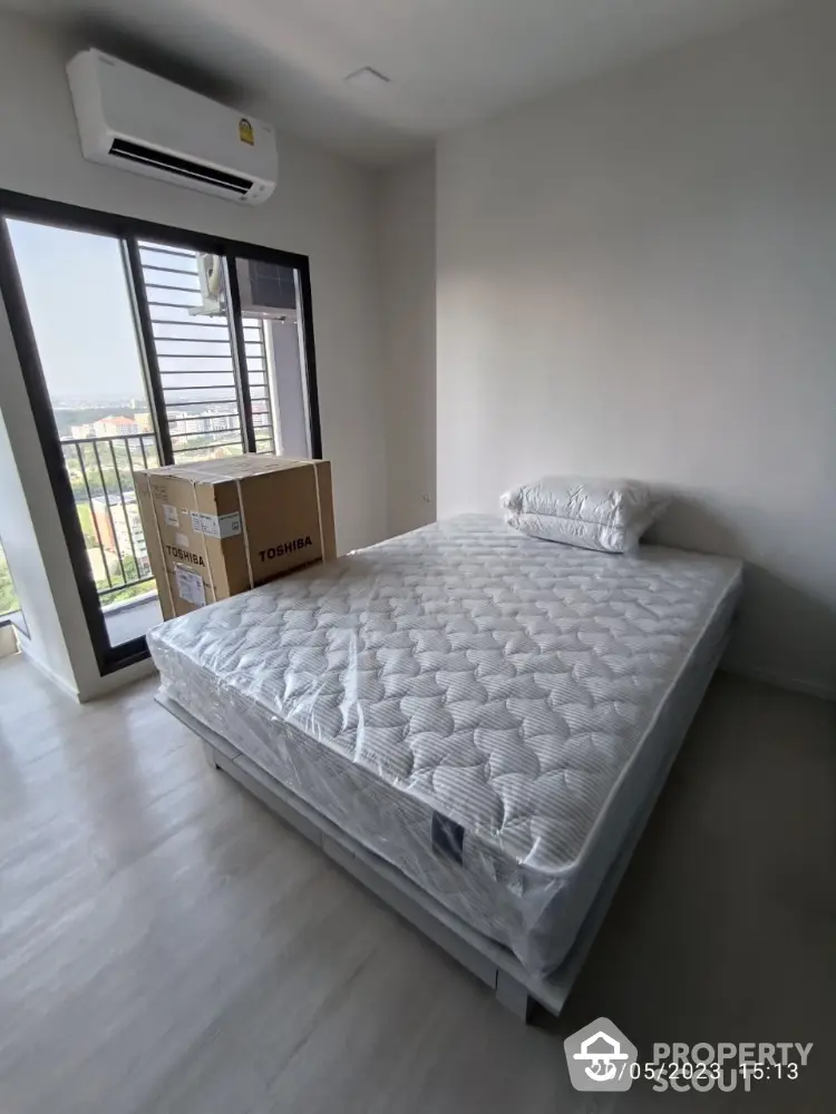 Spacious bedroom with large window and air conditioning, featuring a new mattress and scenic view.