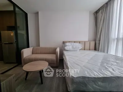 Modern studio apartment with cozy bed and stylish sofa, perfect for urban living.