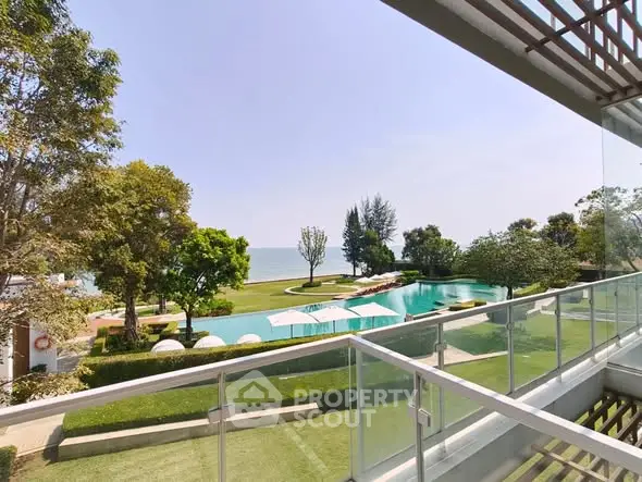 Luxurious balcony view overlooking serene pool and lush garden by the sea