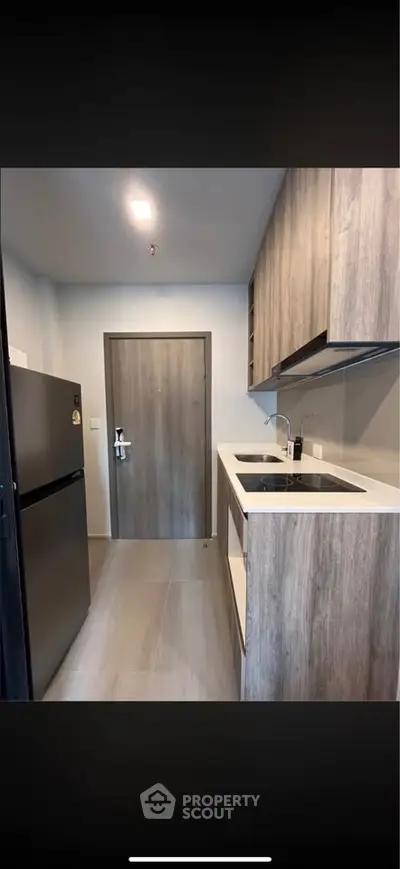 Modern kitchen with sleek cabinetry and built-in appliances in a compact layout.