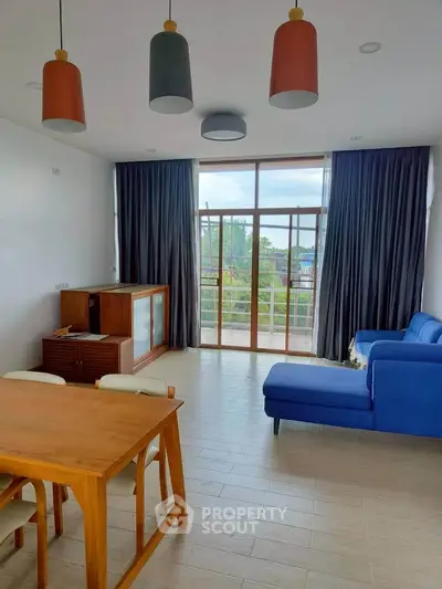 Spacious living room with modern furniture and large windows offering a scenic view.