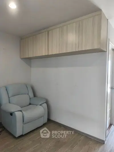 Cozy study nook with armchair and overhead storage cabinets