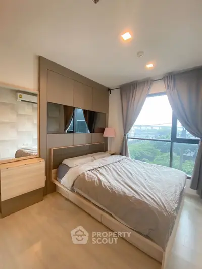 Modern bedroom with large window and stylish decor in a contemporary apartment.