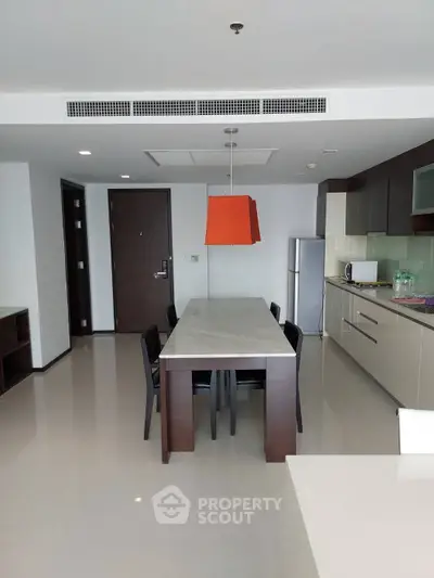 Modern kitchen with sleek cabinetry and dining area in open layout apartment