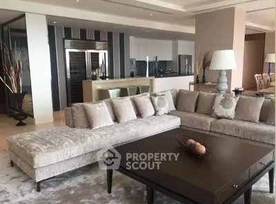 Luxurious modern living room with plush sectional sofa and open kitchen layout, perfect for entertaining.