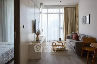 Modern living room with cozy sofa, stylish decor, and large window for natural light.