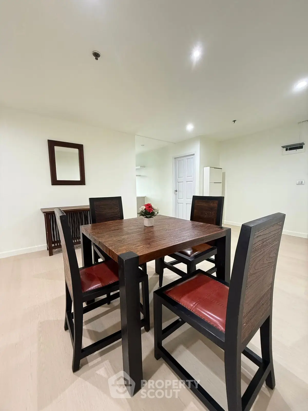 Elegant dining area with wooden table and chairs in a modern apartment.