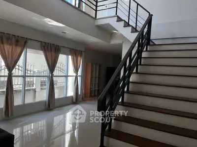 Spacious modern living area with elegant staircase and large windows