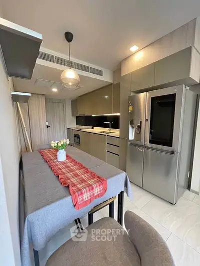 Modern kitchen with sleek cabinetry and stainless steel appliances in a cozy apartment.