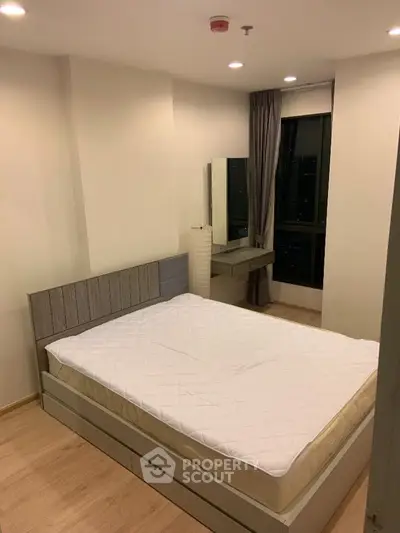 Modern bedroom with stylish furniture and large window in a high-rise apartment.