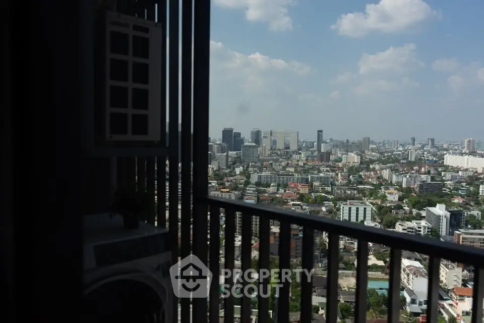 Stunning cityscape view from a high-rise balcony, showcasing urban skyline and blue skies.