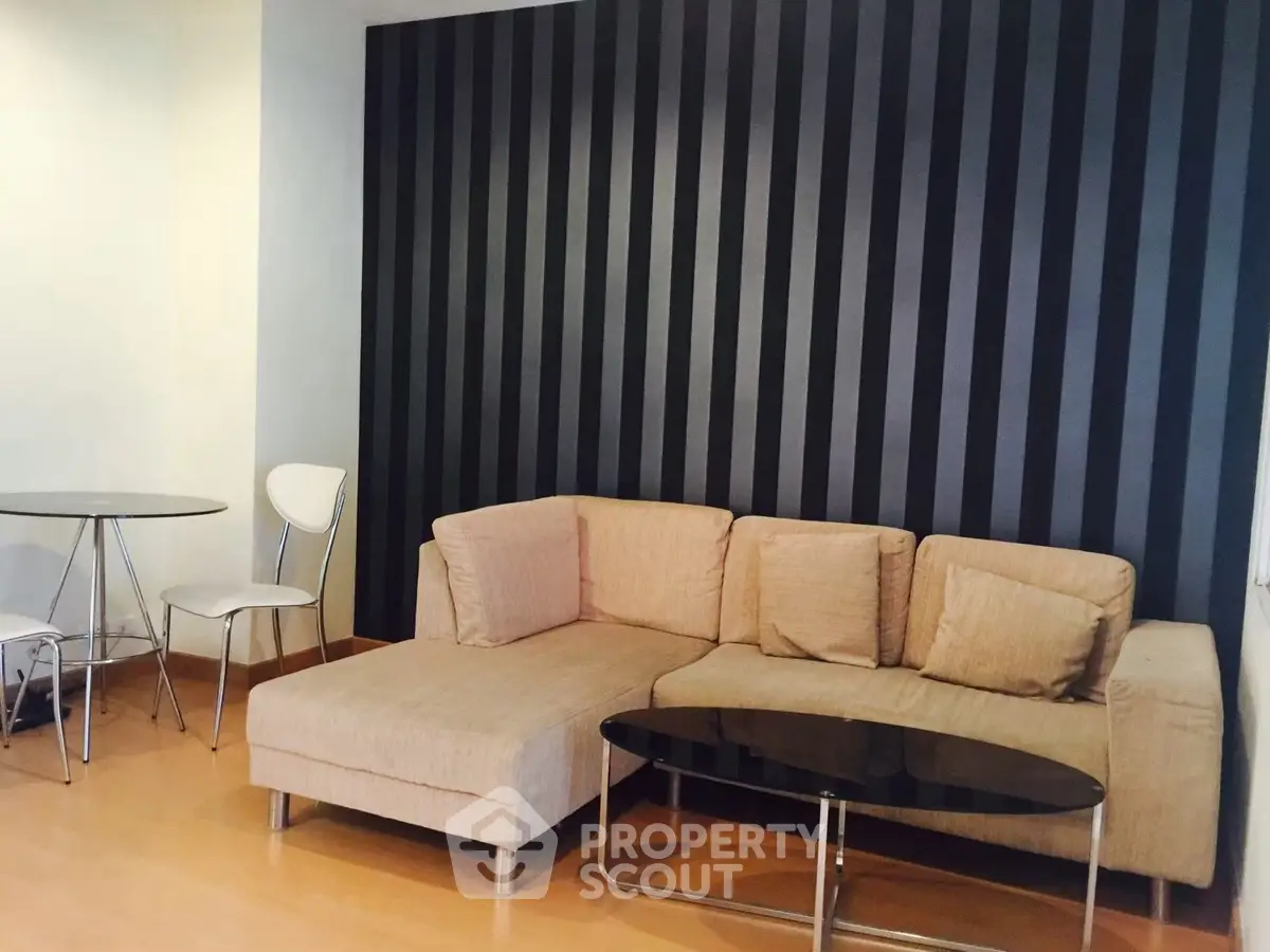 Modern living room with stylish black striped accent wall and cozy beige sofa