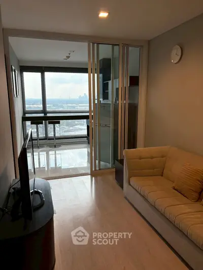 Modern living room with city view and cozy sofa in high-rise apartment.