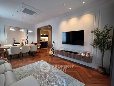 Elegant living room with modern decor, wooden flooring, and wall-mounted TV, perfect for stylish living.