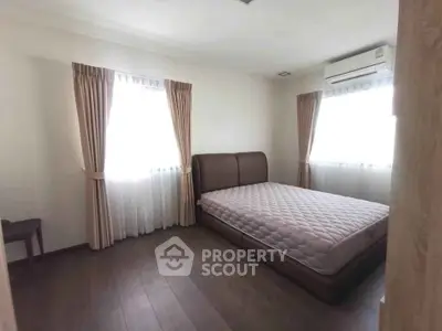 Spacious bedroom with natural light and modern furnishings in a cozy apartment.