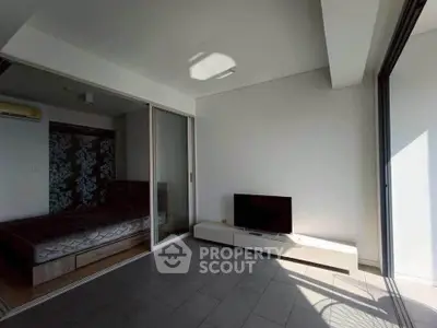 Modern apartment with sliding glass doors and minimalist decor, featuring a cozy bedroom and sleek living area.