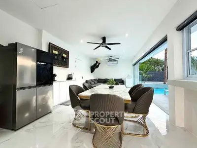 Luxurious open-plan living room with modern dining area and pool view, perfect for entertaining.