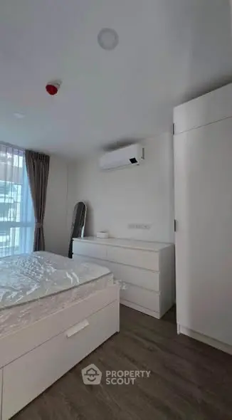 Modern minimalist bedroom with sleek white furniture and natural light