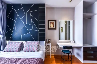 Modern bedroom with stylish geometric accent wall and cozy furnishings.