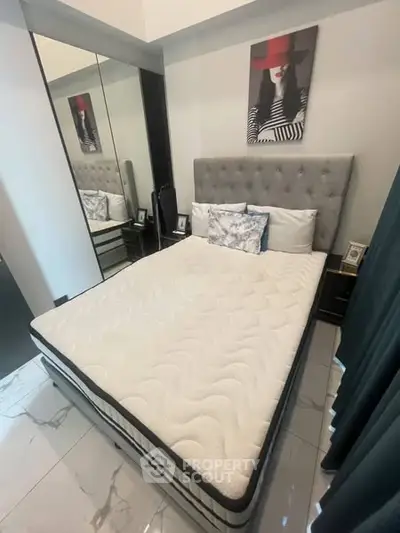 Modern bedroom with stylish decor and mirrored wardrobe in a cozy apartment.