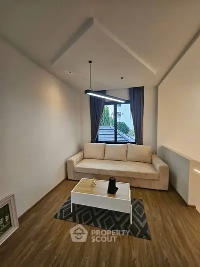 Modern living room with cozy beige sofa and stylish lighting, perfect for relaxation.