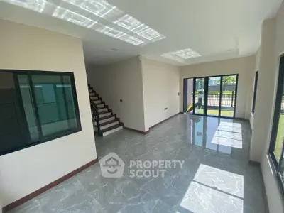 Spacious modern living room with large windows and natural light