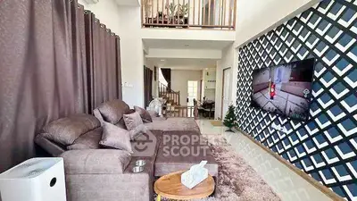 Spacious modern living room with stylish decor and large TV, perfect for relaxation and entertainment.