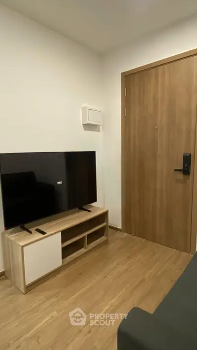 Modern living room with sleek TV setup and wooden flooring