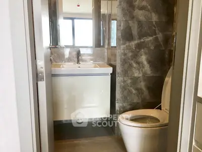 Modern bathroom with sleek design and large mirror in a contemporary apartment.