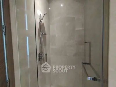 Modern bathroom with sleek glass shower enclosure and contemporary fixtures.