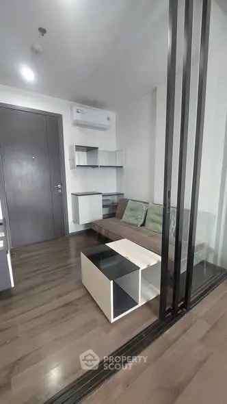 Modern living room with sleek design and glass partition in a stylish apartment.