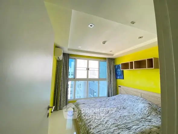 Bright bedroom with large window and modern decor in urban apartment.