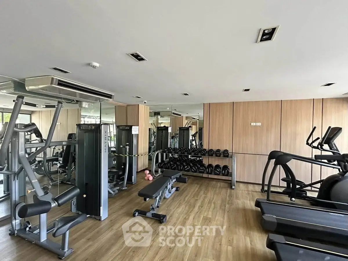 Modern gym with state-of-the-art equipment and mirrored walls in a residential building.