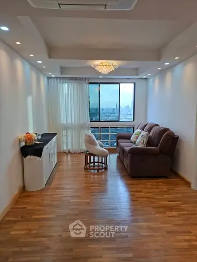 Spacious living room with city view, elegant lighting, and cozy seating area.