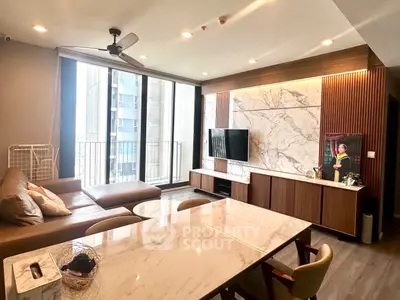 Luxurious modern living room with marble accents and large windows in a high-rise apartment.