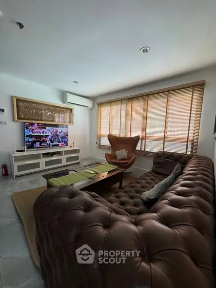 Luxurious living room with plush leather sofa and modern decor, perfect for relaxation and entertainment.