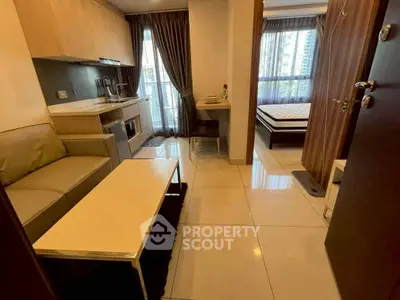 Modern studio apartment with open layout, featuring a cozy living area and a stylish kitchen.