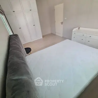 Cozy bedroom with plush bed and ample storage in modern apartment