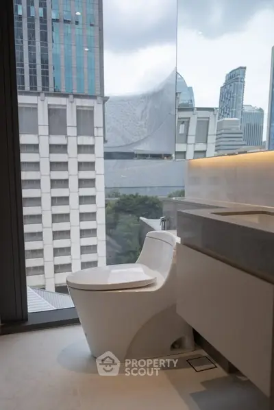 Modern bathroom with city view, featuring sleek toilet and elegant vanity in high-rise apartment.