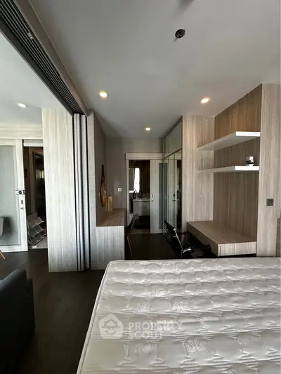 Modern bedroom with sleek design, featuring built-in shelves and a comfortable mattress, perfect for urban living.