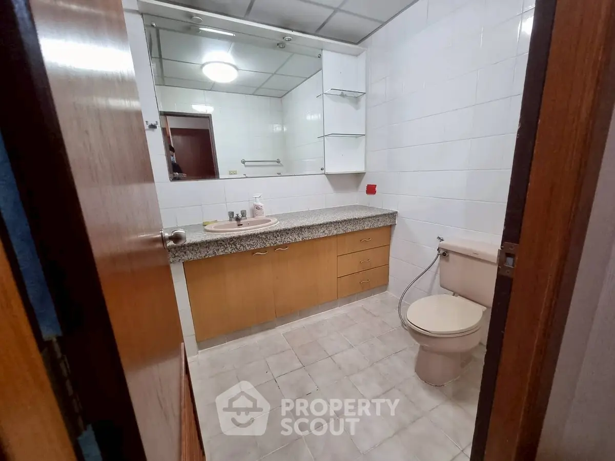 Spacious bathroom with modern fixtures and ample storage in a stylish real estate property.