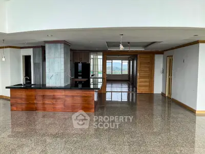 Spacious open-plan kitchen with sleek countertops and panoramic views in modern apartment.