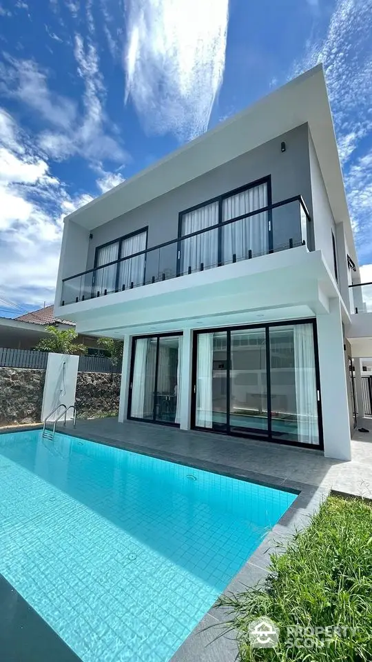 Stunning modern villa with private pool and spacious balcony under a clear blue sky.