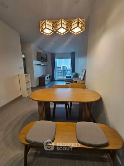 Modern living room with stylish wooden dining set and contemporary lighting