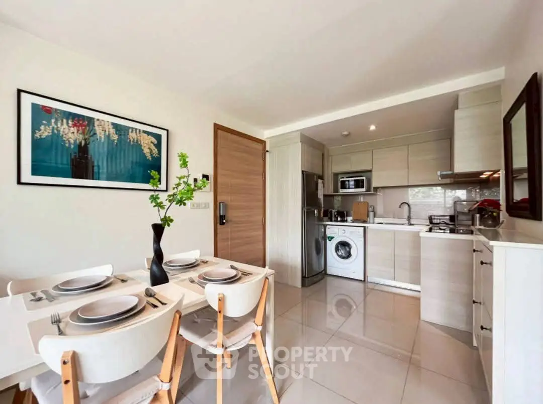 Modern kitchen with dining area, featuring sleek appliances and stylish decor.