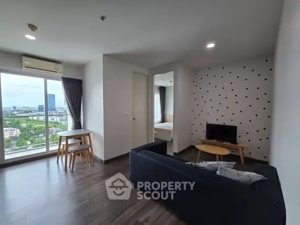 Modern living room with city view, featuring sleek furniture and large windows for natural light.
